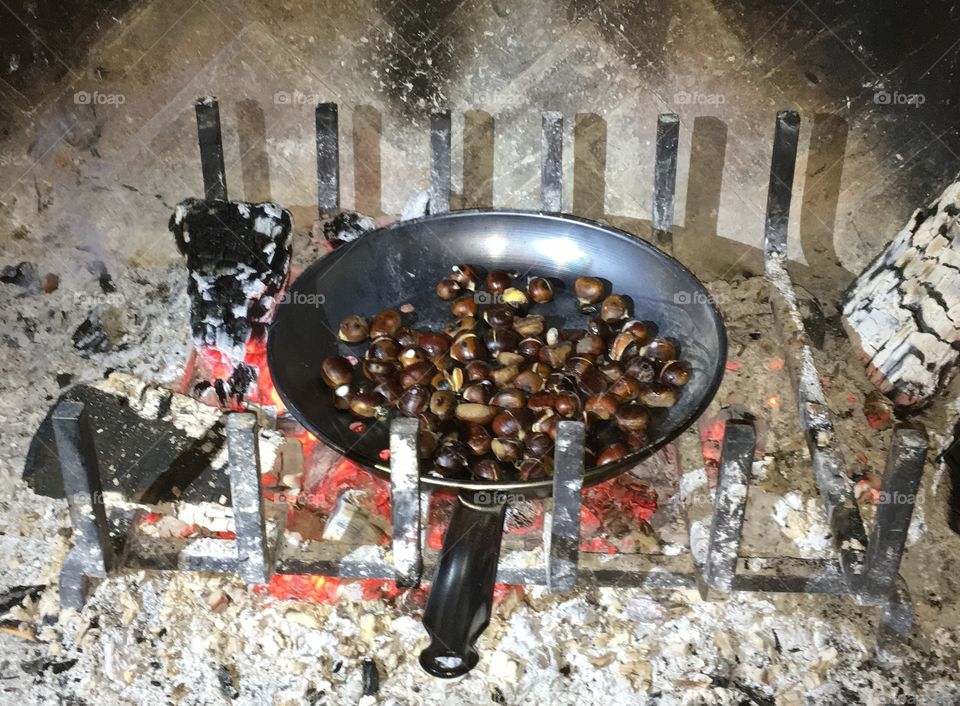 roasted chestnuts over a wood fire in open fireplace 