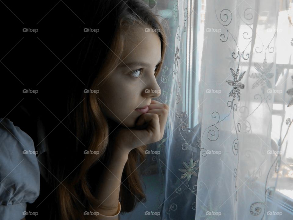 Девушка смотрит в окно 