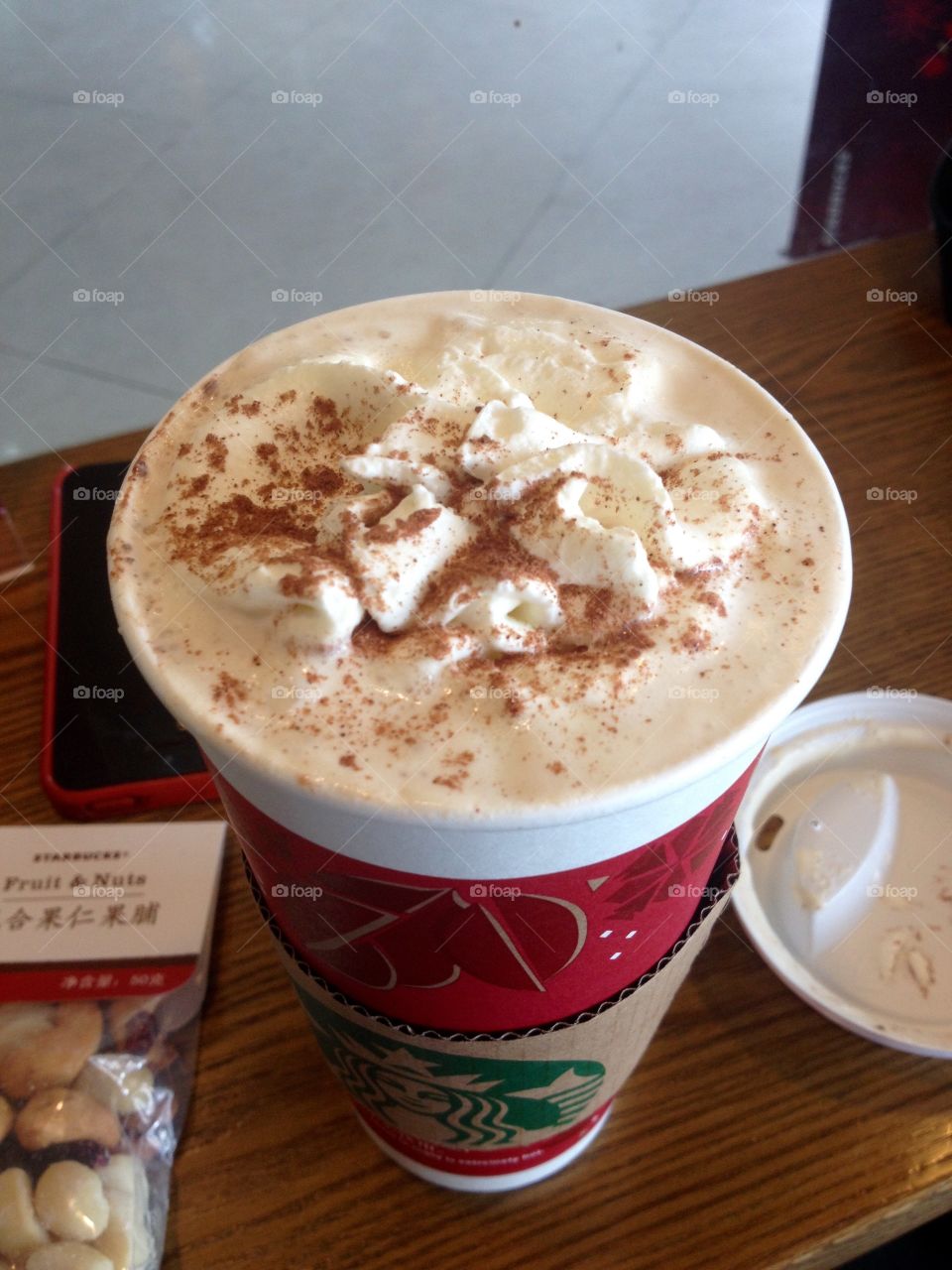 Starbucks coffee with cream in a paper cup on Christmas