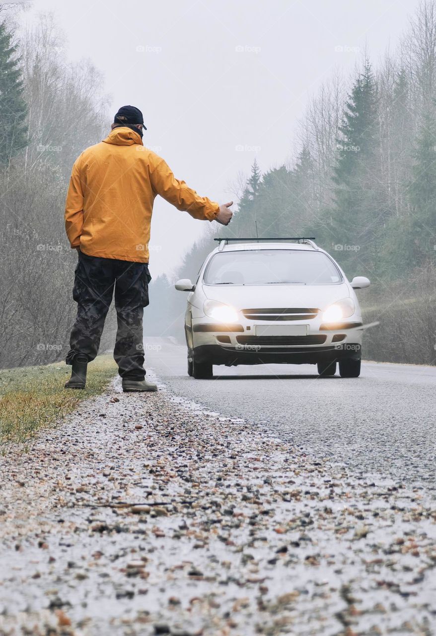 A man stops a car on the road