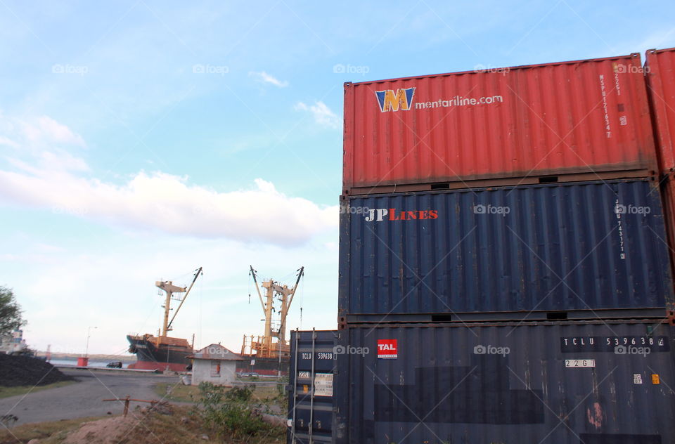 Lanscape viewed for the harbour at the afternoon. What break time of worker to rest ? Ship to the anchored, and look at how's container arranged at the corner of. Colour of red, purple, and etc