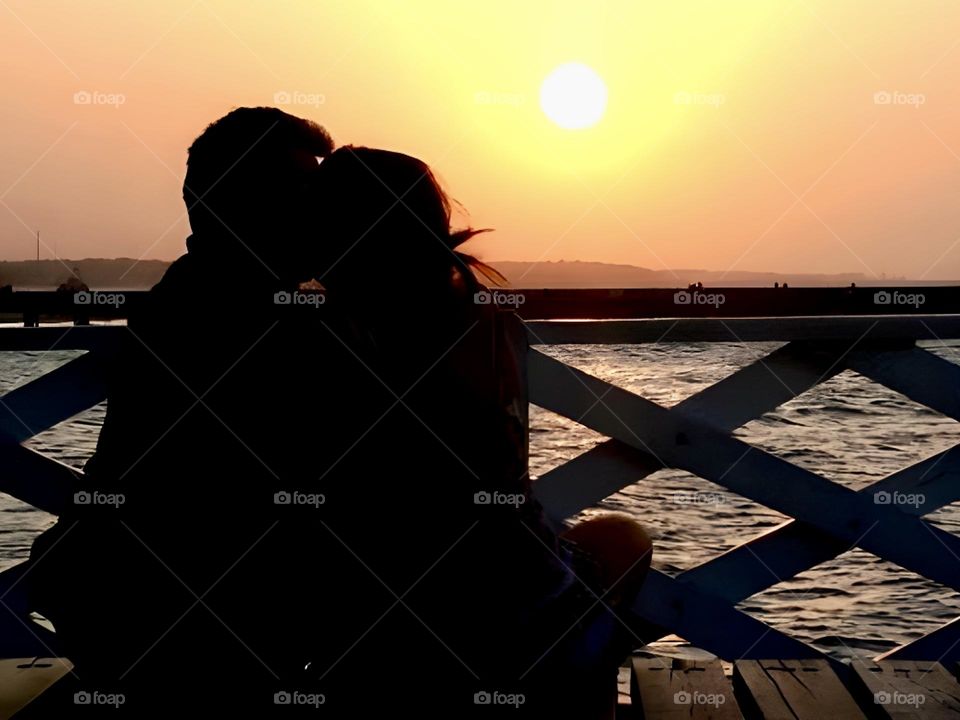 Silhouette of a couple kissing at sunset