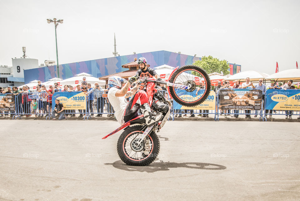 Doing Acrobatics With Motocross Enduro Bike  In Front Of Crowd
