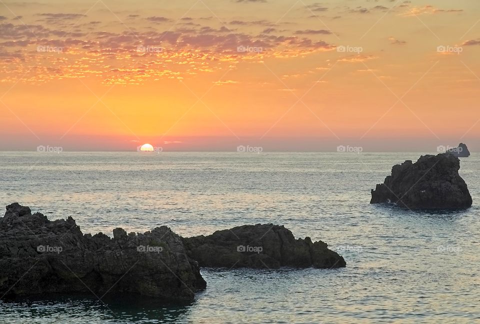 Sunrise on a rocky beach of Isla, Spain