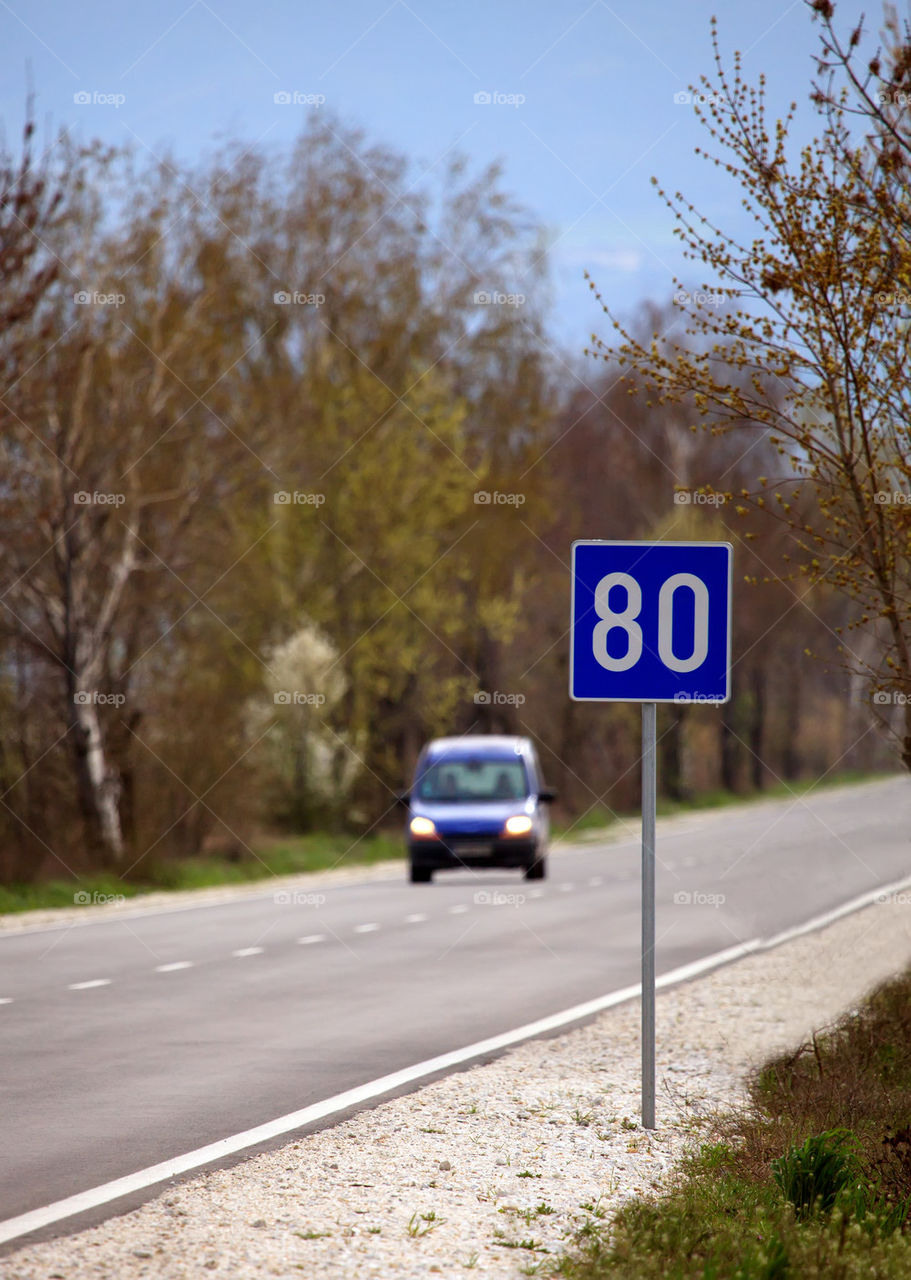 road sign and blurred car