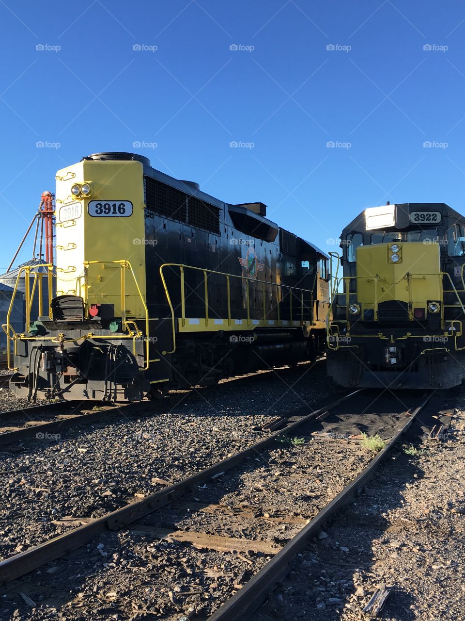 A couple train engines left alone on train tracks 