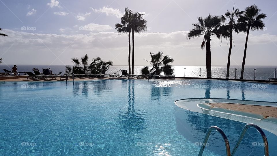 Relaxing by the swimming pool in fair weather 