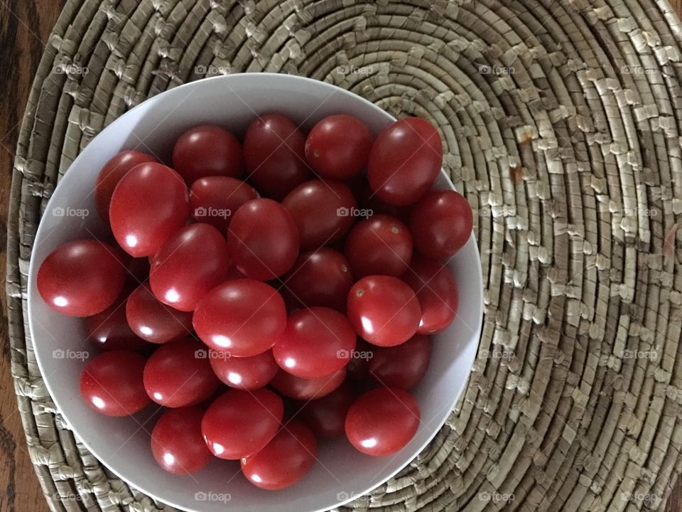 Bowl of tomatoes on straw mat