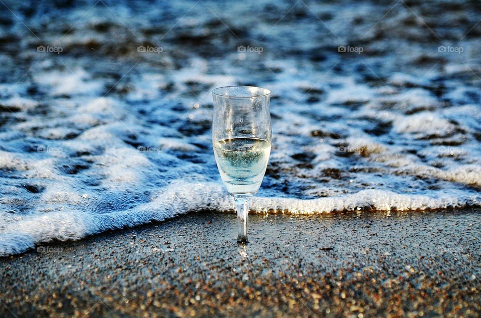 the glass of champagne on the beach at the baltic sea coast