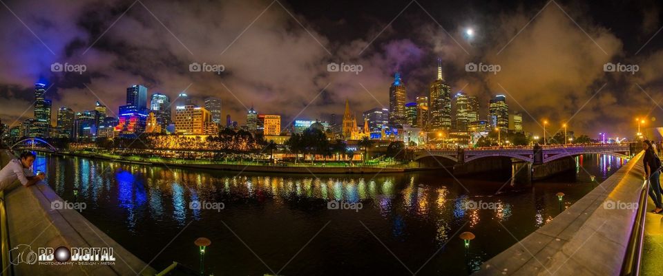Melbourne City Skyline at night. During Moomba festival. The smoke is the sky was from fireworks, really added an interesting orange tint to the sky. Across the Yarra River, great panorama shot stitched together.