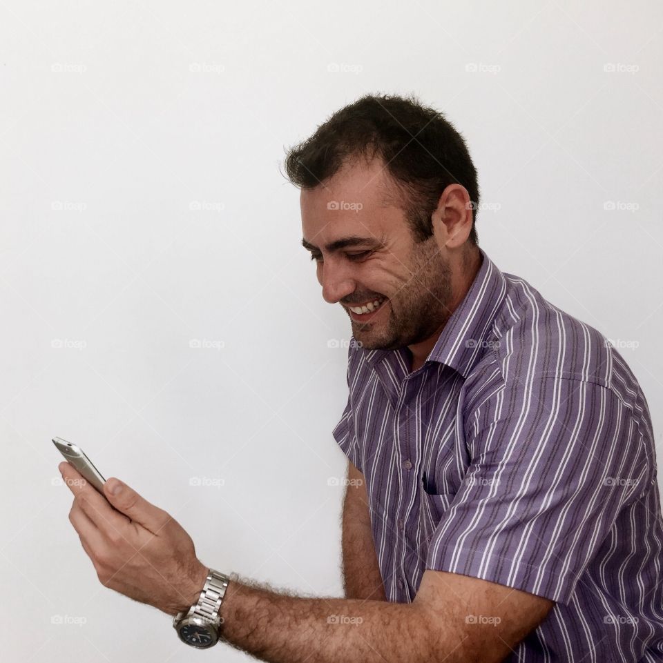Smiling man looking at mobile phone