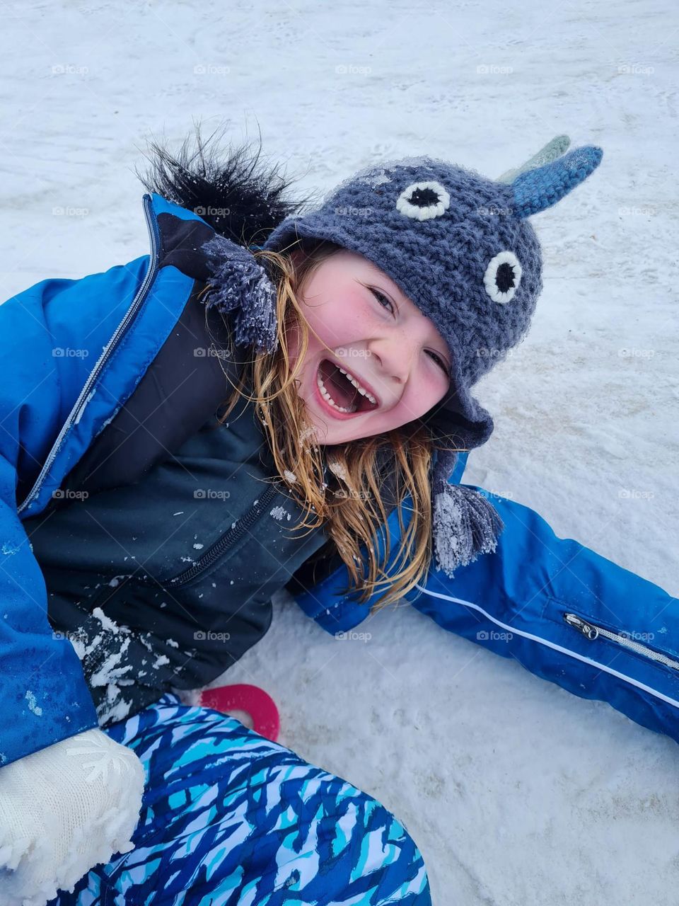 Young girl laughing and having fun in the snow 