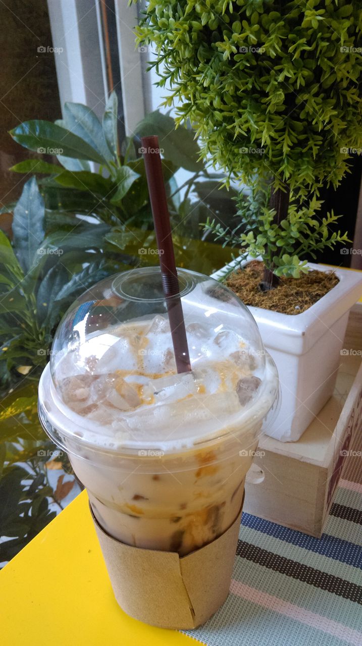 A glass of ice caramel Macchiato on the table.