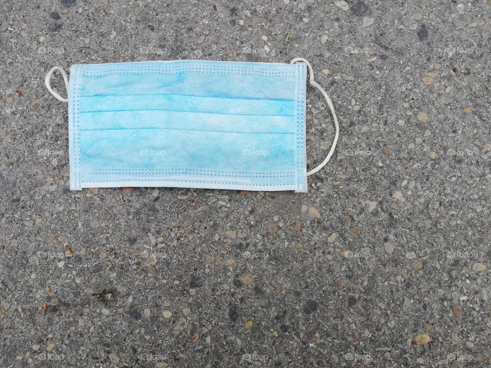 Disposable surgical mask thrown on the ground