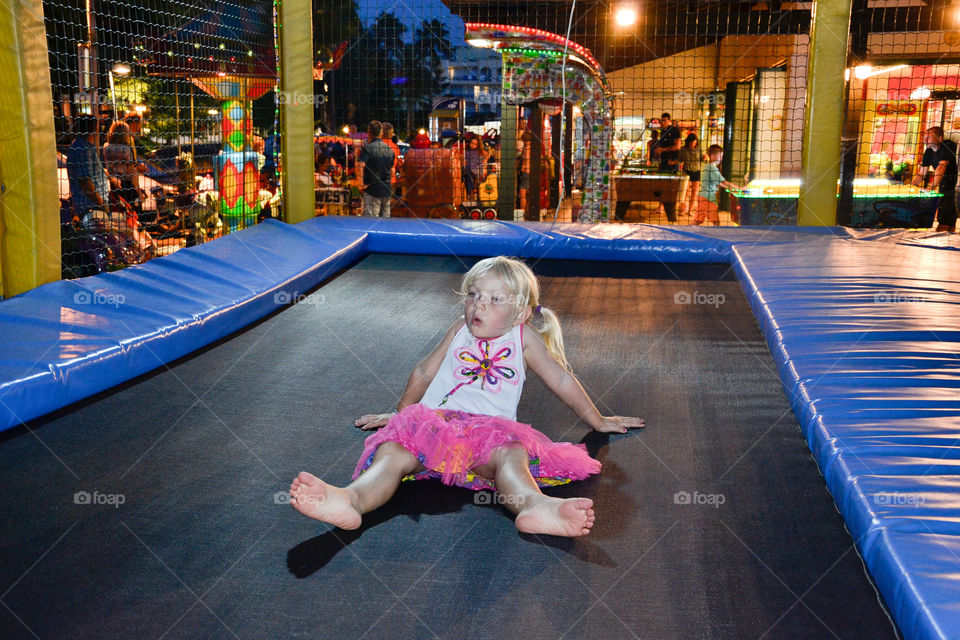 young girl jumping trampoline at theme park in Majorca island.