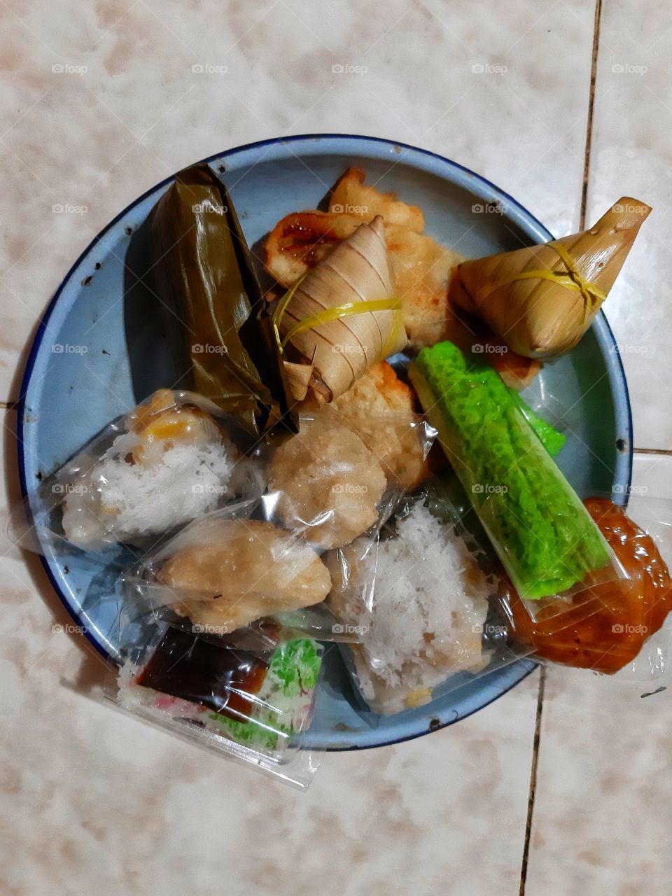 Balinese delicious traditional snacks in a blue round metal plate