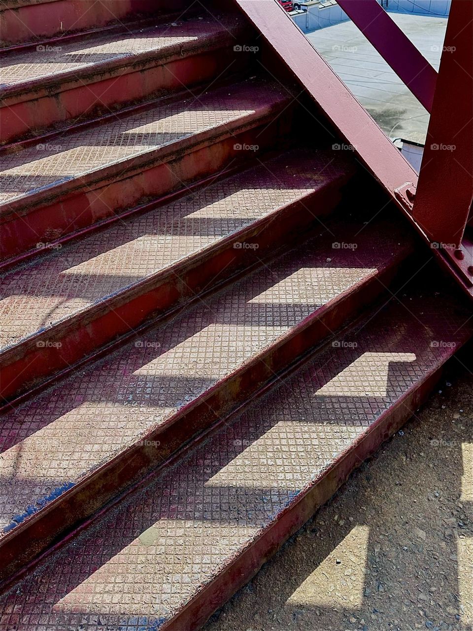 Shadow play in the late afternoon brings things to life as is the case with the “Bauhaus” inspired red metal staircase of the “Pulaski Bridge” at “Newtown Creek” in LIC, Queens. 2024. Hypnotic Productions