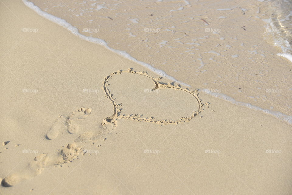 Heart shape carved on sand