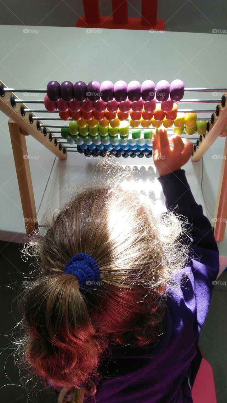 A child plays by Colored pellet setup.