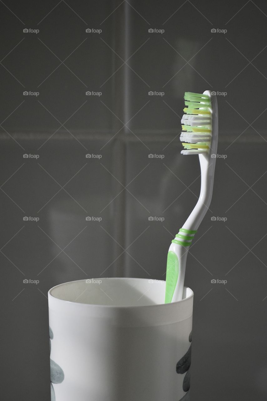 one toothbrush in a cup in close up