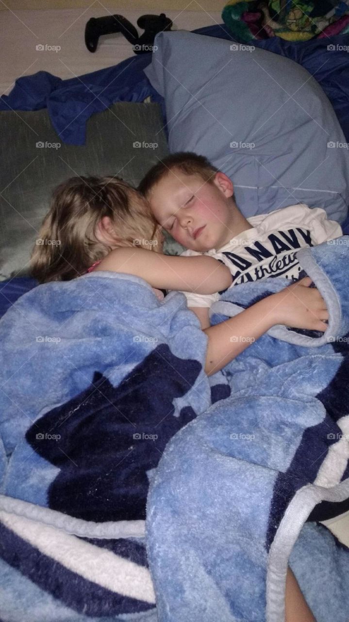 Brother and sister sleeping in on a lazy Saturday morning