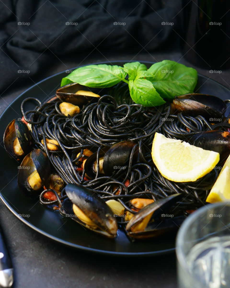 High angle view of black spaghetti with mussels in plate