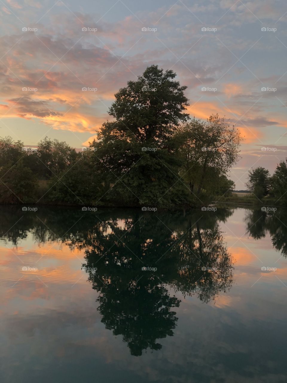 Sunset landscape reflection on a still water pond