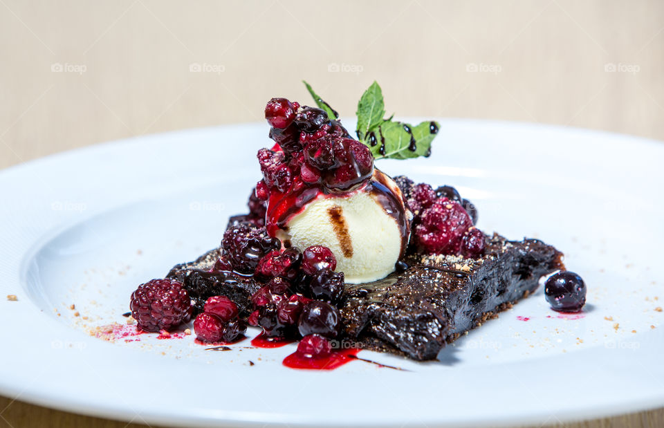 Chocolate brownie with ice cream and rhapsody of forest fruits 