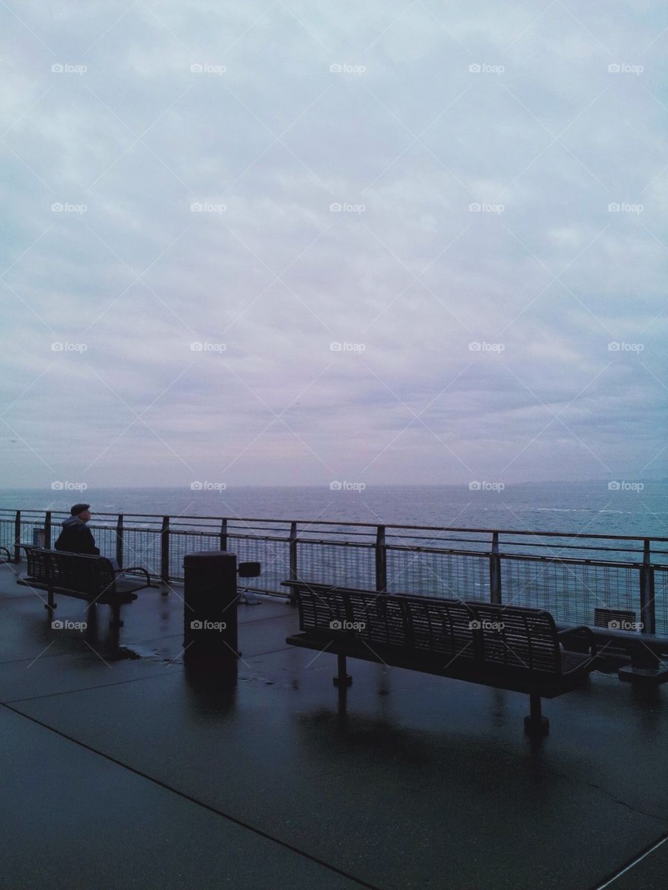 Lone Man Sitting on Bench by Pier