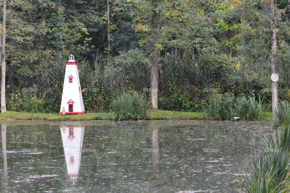 Pond with trees and small lighthouse