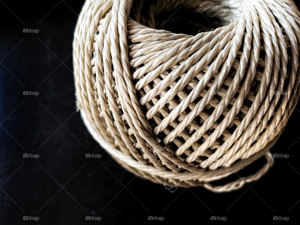 Close-up of a coiled string on black table 