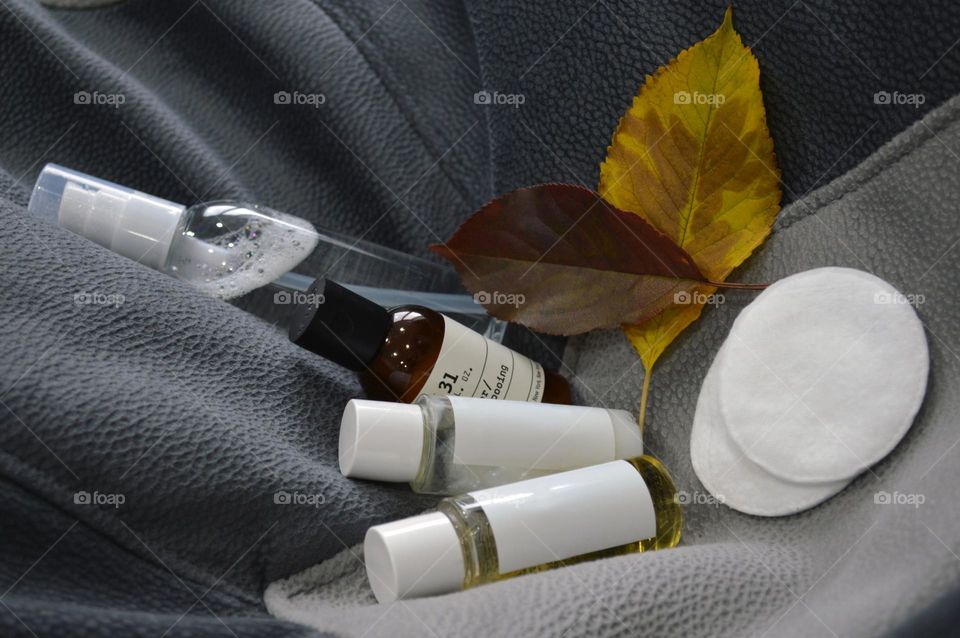 Jars with cream, shampoo and cosmetics on a background with autumn leaves