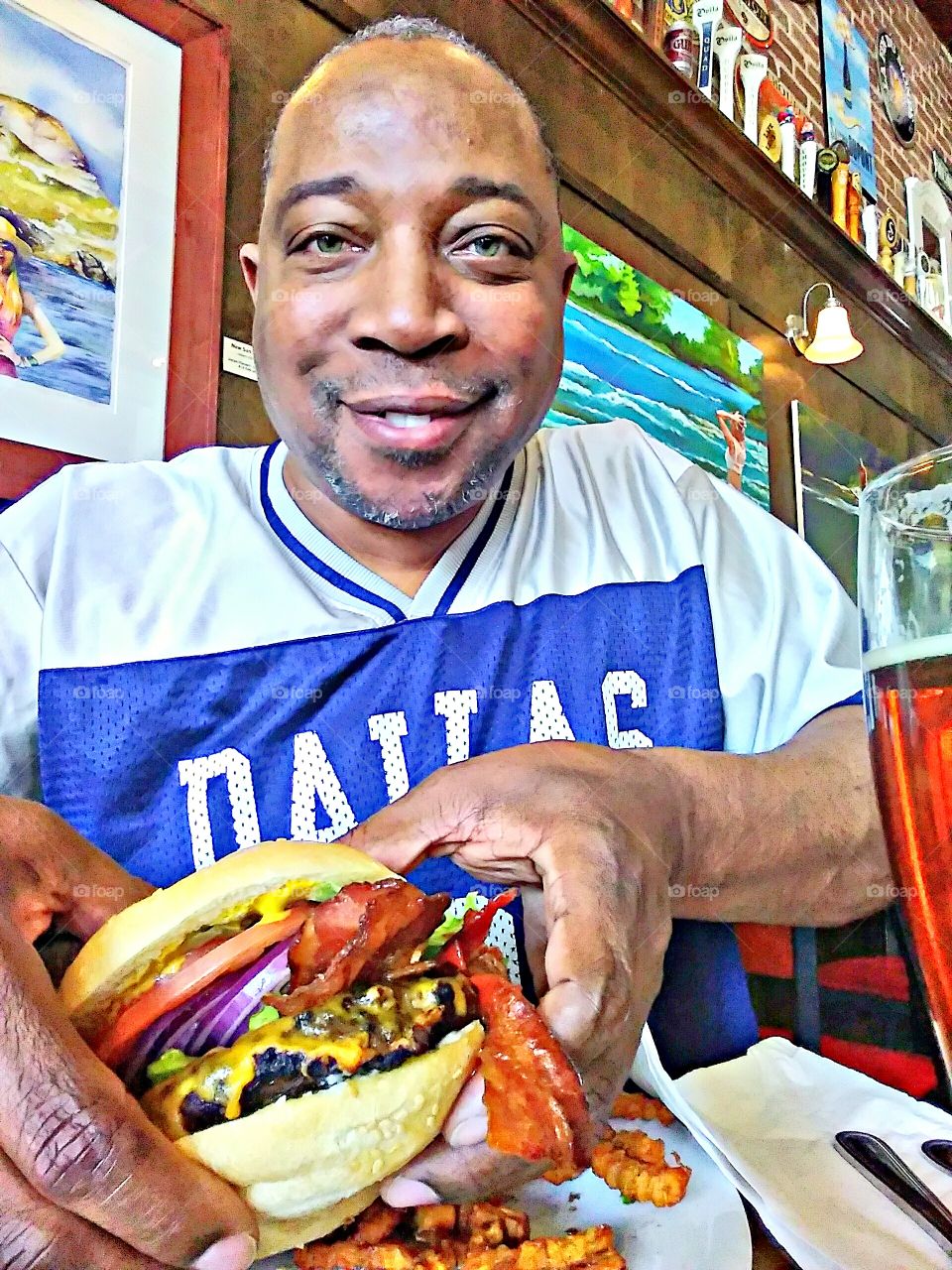 me, Mark Sarden getting ready to stuff my face with a avocado bacon burger with onions and tomatoes while wearing a Dallas cowboy jersey.