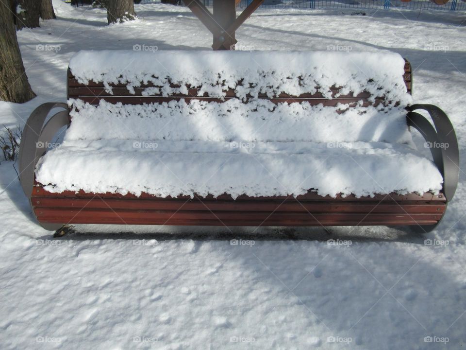 bench under snow in the park