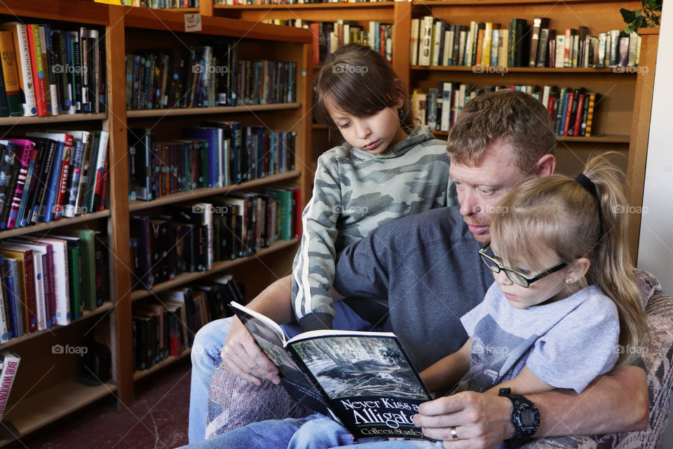 Father reading a book to his children