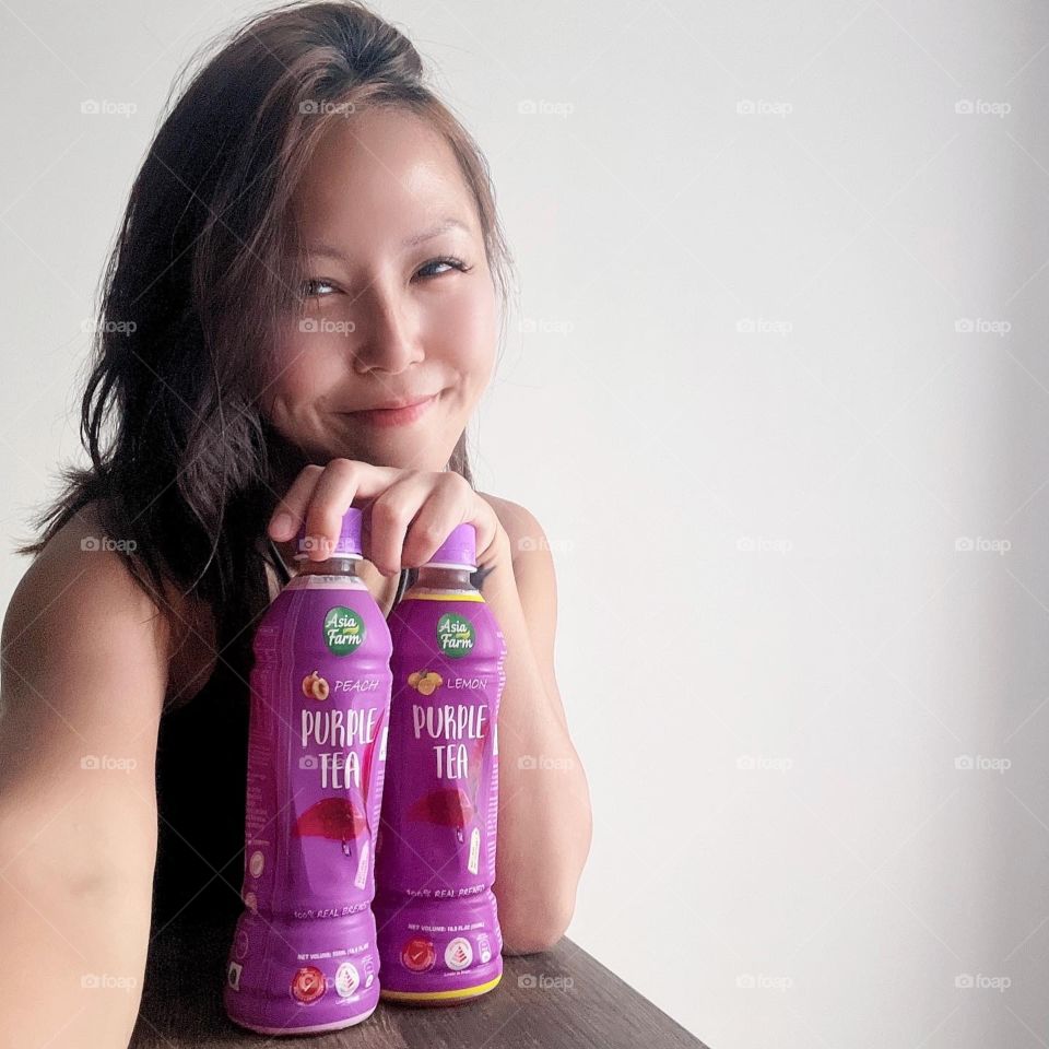 Asian woman with Vibrant purple tea with great health benefits 