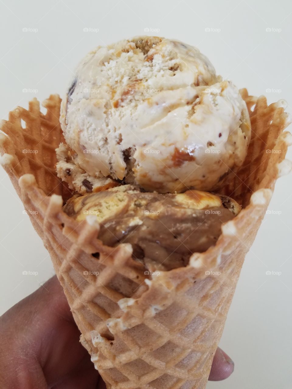 Person's hand holding ice cream cone