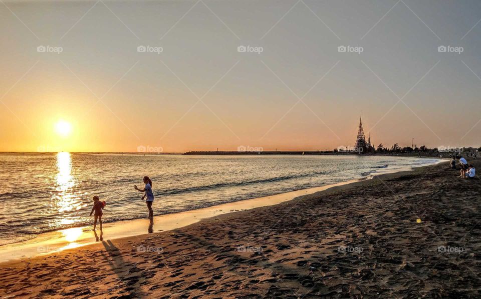 sunrises, sunsets and the moon: offshore island beach sunset. a mother took a picture for her child, warm feeling.