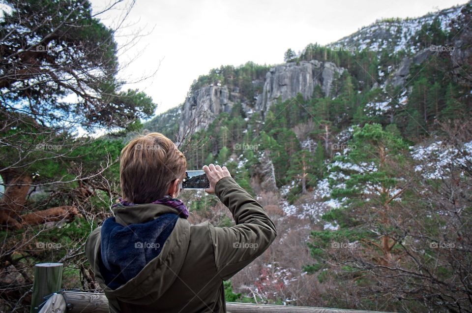 A woman takes a photo with her smartphone in nature