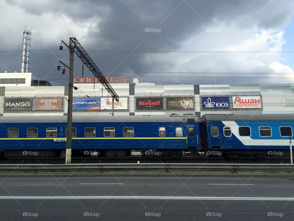 A train passing a mall with ads by