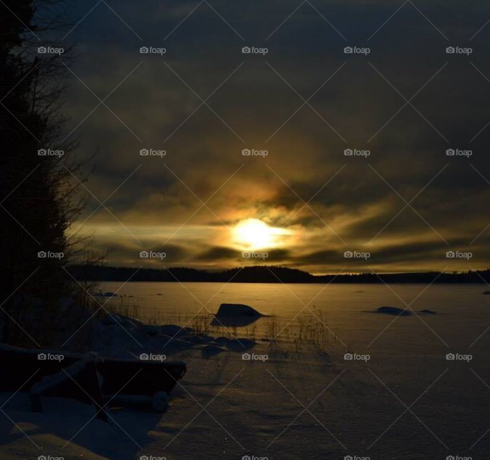 Sunset, lake, winter sunset. Finnish, Finland winter. Dark sky. Snow. 