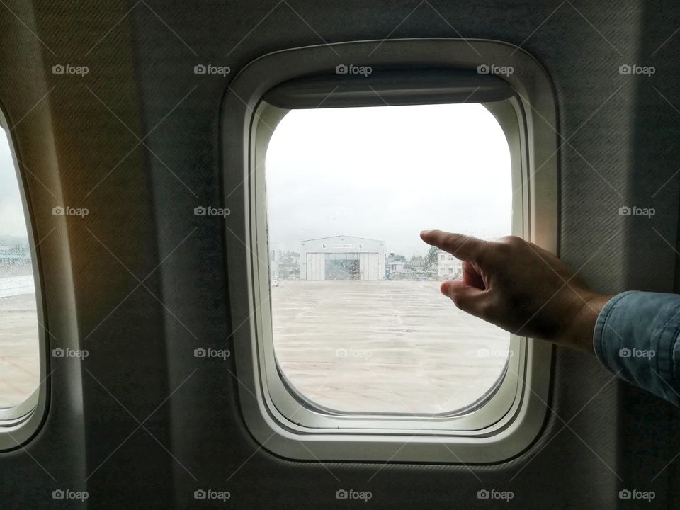 person on the plane points out the window