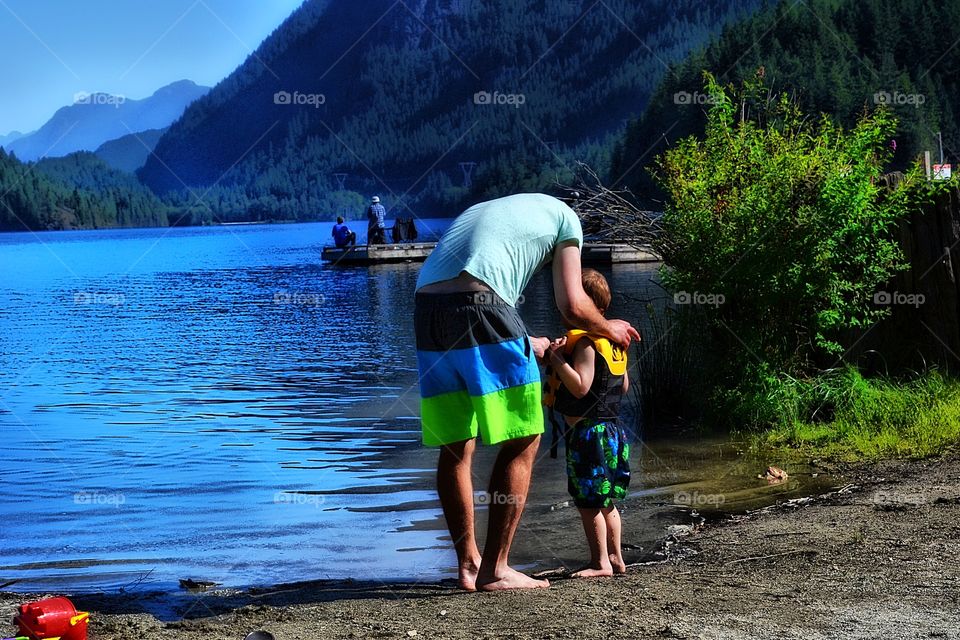 Everything will be okay. Father reassuring his little son at lake