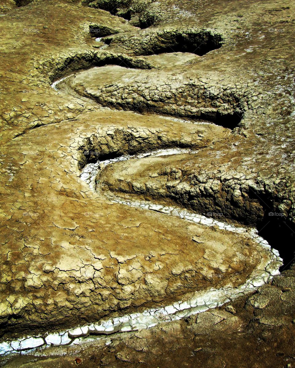 meandering stream of a dried river, muddy volcanoes