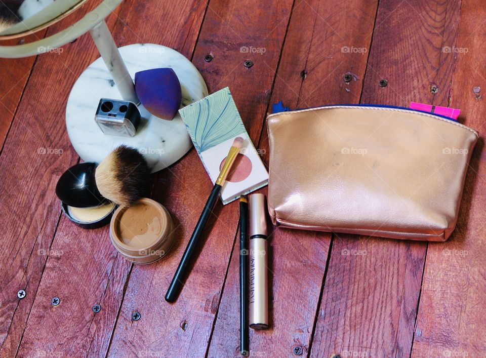A few makeup necessities with a mirror and bag