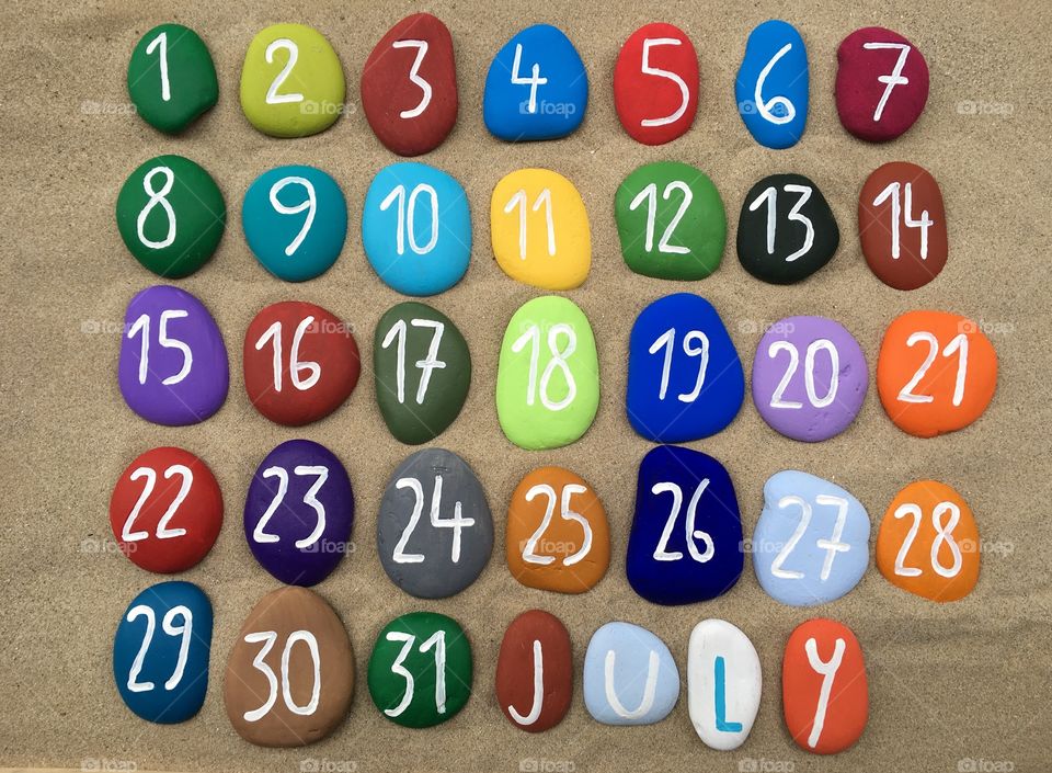 July calendar on colored stones 