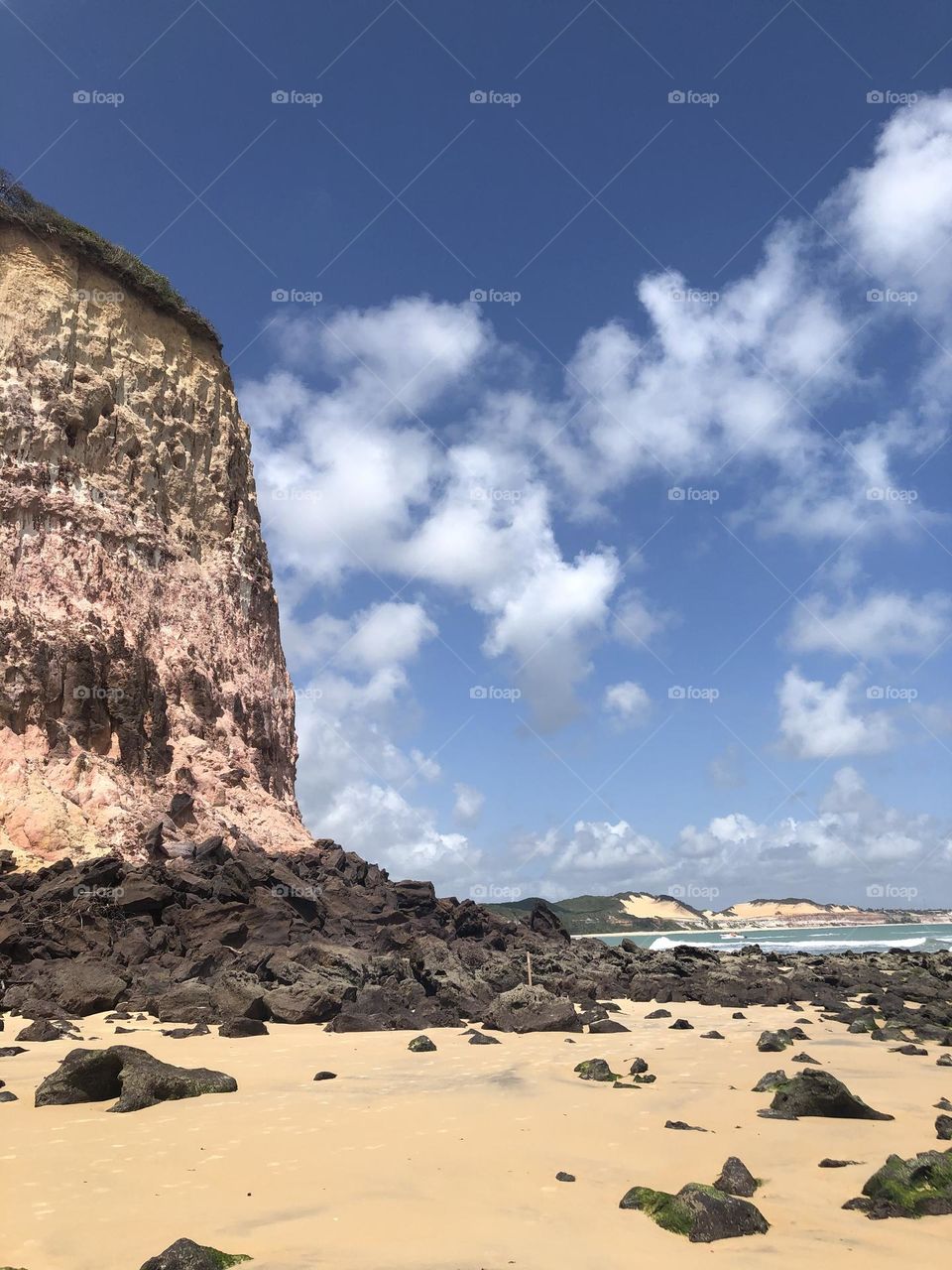 Cliff at the tropical beach full of rocks