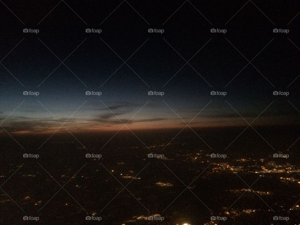 Sunsetting from the air over city 