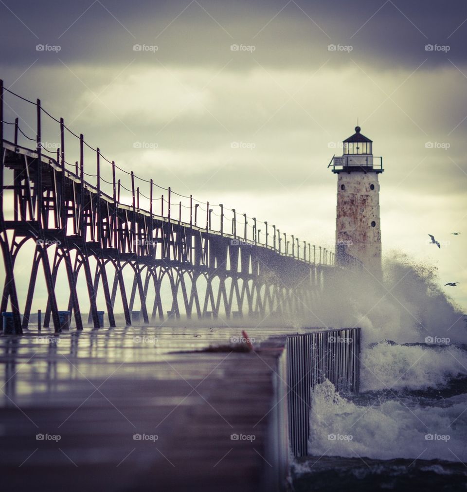 View of lighthouse and bridge in sea