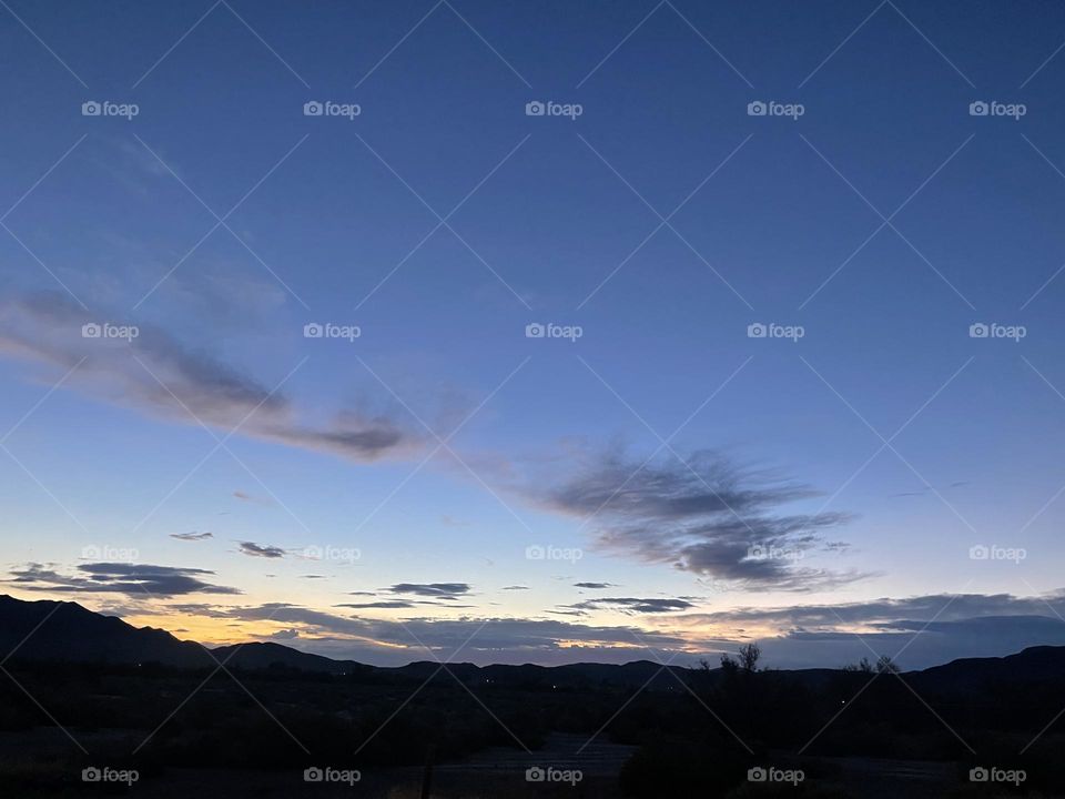 A beautiful and colorful sunset with clouds and mountains.